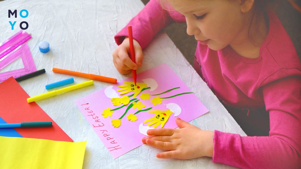 дитина робить великодню листівку