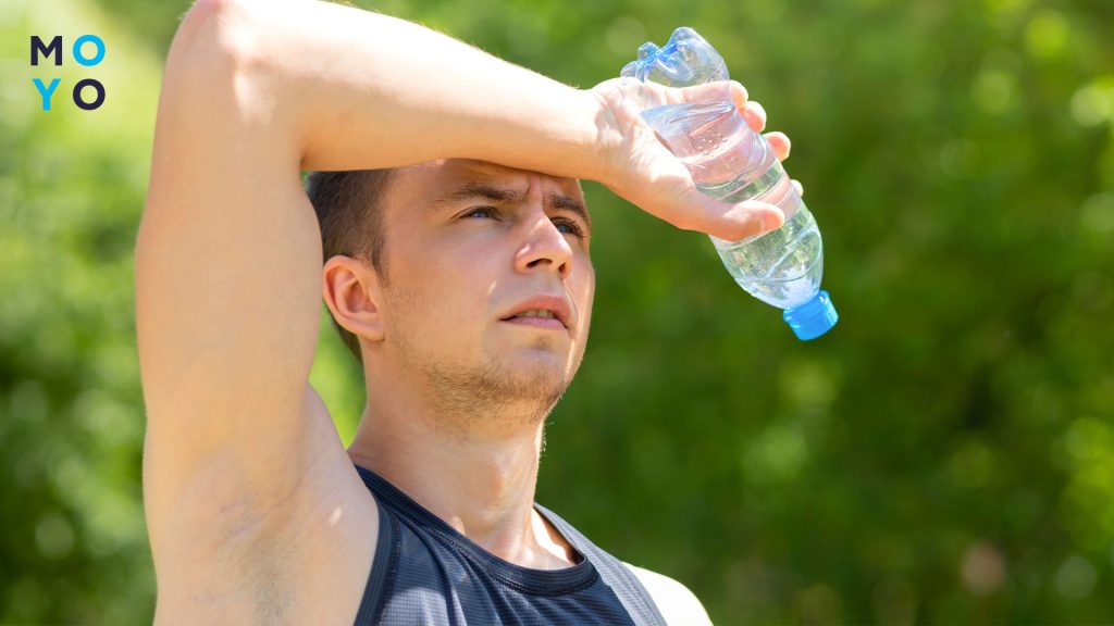 мужчина держит бутылку с водой
